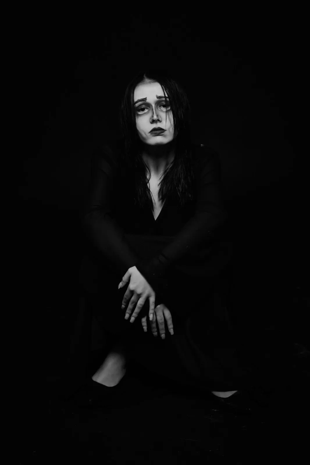 Personnage assis en noir et blanc, maquillage de caractère